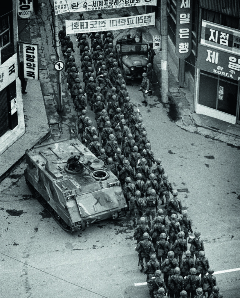 Eine Formation von ca. 100 Fallschirmjägern marschiert an einem Panzer vorbei.